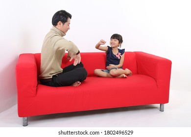 South East Asian Young Father Daughter Parent Girl Child On Red Sofa Playing Fun Happy Smile On White Background