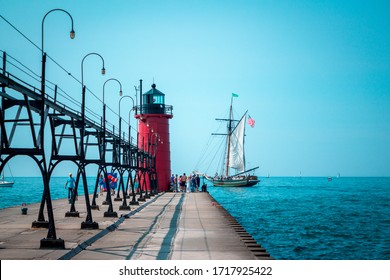 South Haven, MI /USA - September  16th 2017:  Tall ship sailing past a lighthouse on a summer day in South Haven