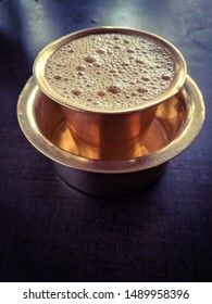 South Indian filter coffee served in gold serve ware.