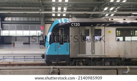 South indian kochi metro public passenger electric train front side with closed door arriving and passing through aluva metro station platform terminal background with copy space. Closeup side view.