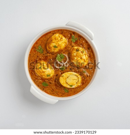 South Indian Style Egg Curry Recipe close-up in a bowl on the table on white background. Horizontal top view from above