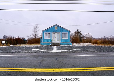 South Kingstown, RI/USA- February 18, 2019: A horizontal roadside image of a vintage blue beach cottage in southern Rhode Island. 