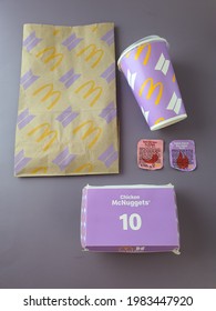 South Korea BTS Boy band superstars McDonald's BTS Meal empty packaging. Paper bag, drink cup, nuggets box and dipping sauce cover. Purple background. Collectible item. Malaysia. May 2021