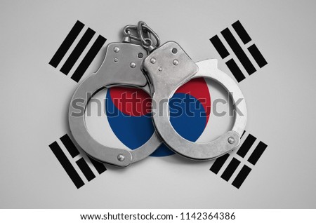 South Korea flag  and police handcuffs. The concept of observance of the law in the country and protection from crime