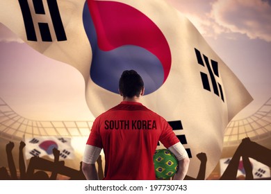 South Korea Football Player Holding Ball Against Large Football Stadium Under Bright Blue Sky