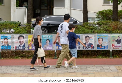 A South Korean Family Pass Poster Of Local Election Candidates On A Street In Seoul, South Korea, May 29, 2022.