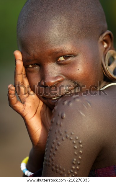 SOUTH OMO - ETHIOPIA - July 25, 2014:\
Unidentified young Mursi woman on July 25, 2014 in South Omo,\
Ethiopia. A 5-year ongoing resettlement program started 2011\
threatens the tribes in\
Ethiopia.