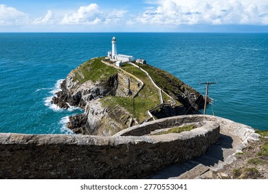 South Stack Lighthouse on Holy Island near Holyhead, Anglesey, Wales, standing on a rocky sea stack with dramatic cliffs and views across the Irish Sea along the rugged Welsh coastline.