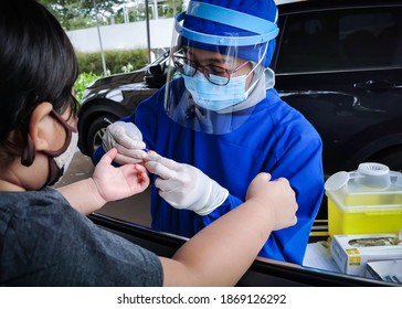 South Tangerang, Indonesia - November 30, 2020: Taking Blood Sample On Drive Thru Covid-19 Rapid Test Service By Nurse To Young Kid At Hospital Parking Area