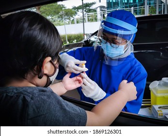 South Tangerang, Indonesia - November 30, 2020: Drive Thru Covid-19 Rapid Test Service By Nurse To Young Kid At Hospital Parking Area