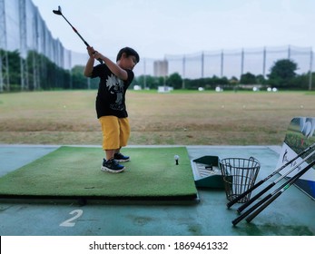 South Tangerang, Indonesia - November 9, 2020: Young Kid Golf Backswing Position At Golf Driving Range From Side View