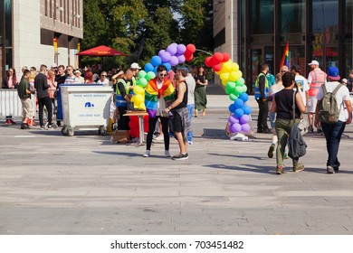 SOUTHAMPTON, UK - August 26 2017: Southampton Pride 2017, City's Second Annual Pride Event, In Southampton UK. Two Men Talking At The Entrance With A Rainbow Balloon Arch Behind Them.