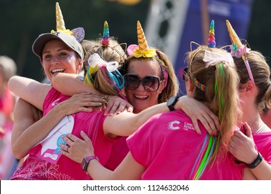 SOUTHAMPTON, UK - July 1 2018: Race For Life, Women Run And Walk To Raise Money For Cancer Research Charity, In Southampton UK. Group Of Women Dressed As Unicorns Hugging After Finishing The Race.