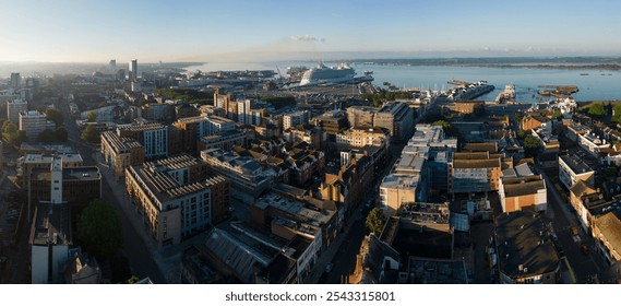 Southampton UK seaside city panorama. Wide angle aerial view from the ferry terminal and port with large cruise ship mooring towards the Itchen toll bridge. Beautiful sunrise and calm sea. Urban area. - Powered by Shutterstock