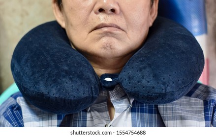 Southeast Asian, Chinese Old Man Taking A Nap On Neck Pillow During Daytime In His Home. Tiredness Can Cause Sleepy.