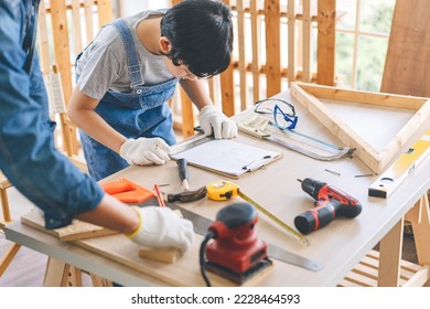 Southeast asian family father and son diy or repair at home concept. Dad teach using tools about carpenter or engineer education skill with child at workshop. - Shutterstock ID 2228464593