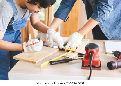 Southeast asian family father and son diy or repair at home concept. Dad teach using tools about carpenter or engineer education skill with child at workshop.