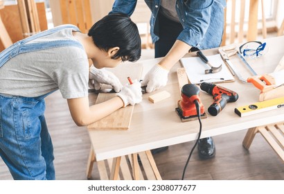 Southeast asian family father and son diy or repair at home concept. Dad teach using tools about carpenter or engineer education skill with child at workshop. Activity homeschooling.