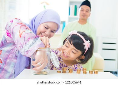 Southeast Asian Family Saving Money At Home. Muslim Family Living Lifestyle.