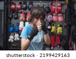 A Southeast Asian female MMA athlete puts her game face on as she poses for the camera showing the correct fighting position.