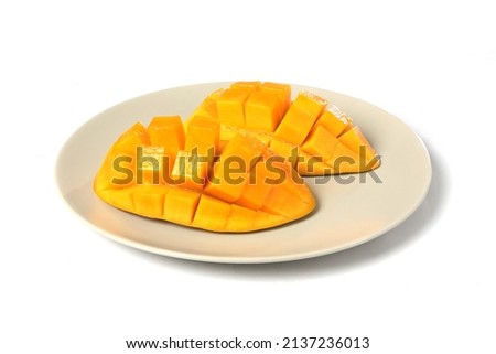 Southeast Asian fruit, fresh hedgehog style Mango preparation, cubes and chunks on Dutch white plate, isolated on a white background. Organic food.