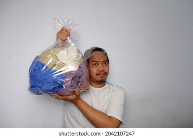 Southeast Asian Man Wearing Cap Carrying And Showing Dirty Laundry In The Transparent Plastic Bag