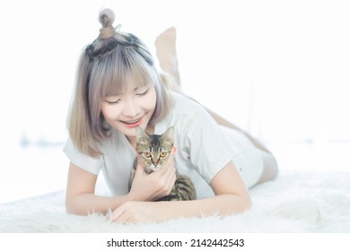 southeast asian woman relaxing with cat - Shutterstock ID 2142442543