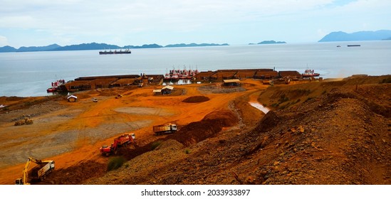 Southeast Sulawesi, Indonesia. February 24th 2019. In the morning, nickel ore is loaded onto barges from the stockpile at the jetty, and loaded onto an mother vessel for export aboard.