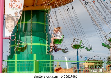 Southend-on-Sea, Essex / UK - JUN 02 2019:  Little Girl In White Having Fun By Riding Green Carousel