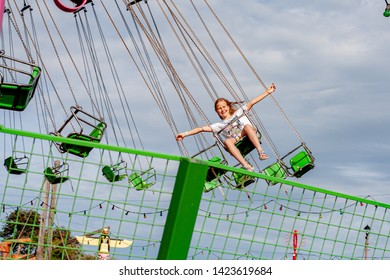 Southend-on-Sea, Essex / UK - JUN 02 2019:  Little Girl In White Having Fun By Riding Green Carousel