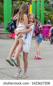 Southend-on-Sea, Essex / UK - JUN 02 2019: Bigger Girl Carrying Little One