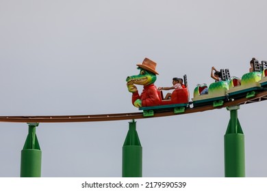 Southend-on-Sea, UK  July 17th 2022  Children On A Roller Coaster With Crocodile Cartoon Character Lead Car. Isolated Against Clear Sky Background. Green Scream, Adventure Island