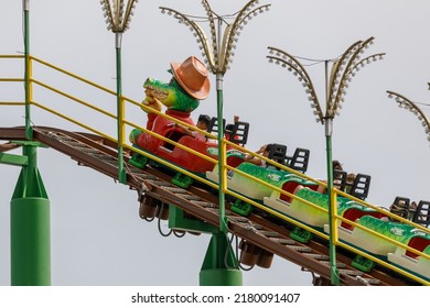 Southend-on-Sea, UK  July 17th 2022  Kids Roller Coaster. Children On A Roller Coaster With Crocodile Cartoon Character Lead Car. Isolated Against Clear Sky Background. Green Scream, Adventure Island