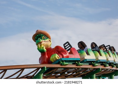 Southend-on-Sea, UK  July 23rd 2022  People Laughing On A Roller Coaster Train Travelling Along A Track With Blue Sky Background.