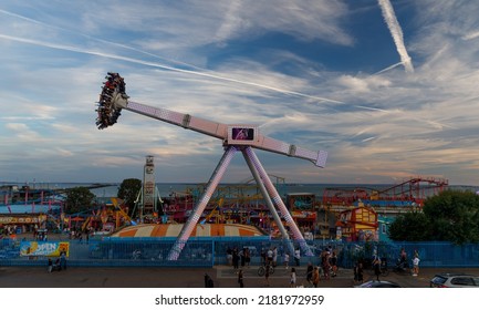 Southend-on-Sea, UK  July 23rd 2022  A Pendulum Swing Ride Roller Coaster At Sunset At An Amusement Park By The River Thames