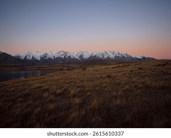 Southern Alps idyllic remote calm serene golden hour snow capped mountain peaks, Lake Heron winter sunset landscape, Ashburton Lakes Canterbury South Island New Zealand - Powered by Shutterstock - Get 15% off with code: PIKWIZARD15