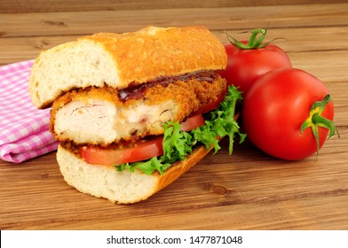 Southern Fried Chicken Steak Sandwich With Fresh Salad On A Wood Background