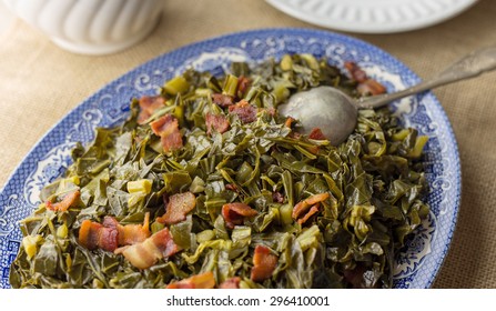 Southern Style Collard Greens With Bacon Served On An Antique Plate With Burlap Table Runner.  