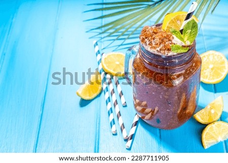 Southern Sweet Tea Slushy. Cold summer tea slush dessert, made with crushed iced tea and lemon juice, on sunny blue wooden background copy space