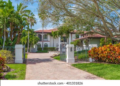 Southwest Florida Concrete Block and Stucco Home with beautiful tropical landscaping and a tile roof and fountain. 