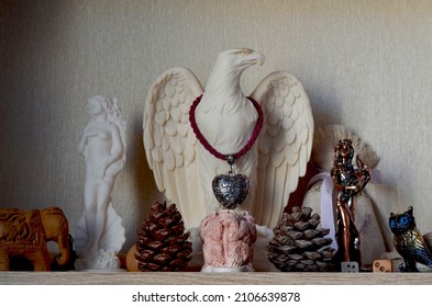 Souvenir shelf with plaster figurines of Aphrodite and an eagle and monkeys, pine cones, a figure of the goddess of fortune, a wooden elephant, a shelf in a niche with decor, various figurines 