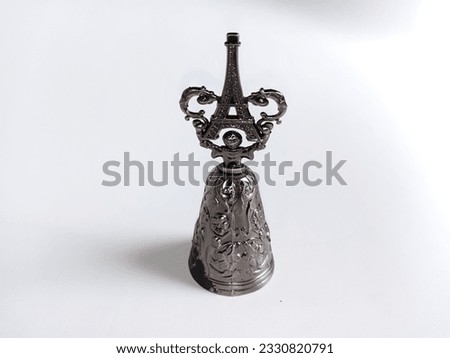 souvenirs from paris in the form of a bell and eiffel tower made of light iron with isolated white background and copy space