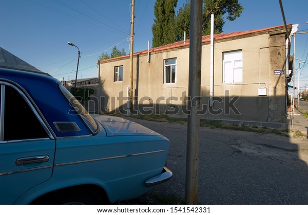 A soviet made car and house in outskirts of\
Gumry, Armenia