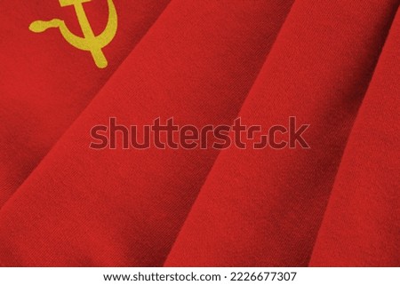 Soviet Union flag with big folds waving close up under the studio light indoors. The official symbols and colors in fabric banner