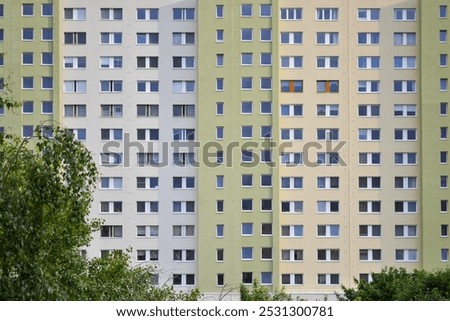 Soviet-type apartment block, facade of a Typical Bratislava-Petržalka Panel Building with Windows and Tree Canopy