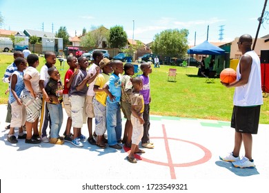 Soweto, South Africa - December 11, 2010: African Children Lining Up To Take Turns To Take A Goal Shot On Public Playground Basketball Court