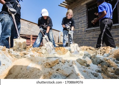 Soweto, South Africa - September 05, 2009: Diverse Community Outreach Program Mixing Cement For Building A Small Affordable House