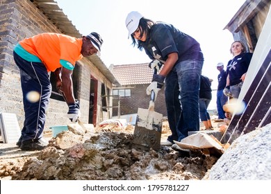 Soweto, South Africa - September 05, 2009: Diverse Community Outreach Program Mixing Cement For Building A Small Affordable House