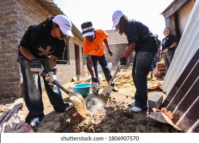 Soweto, South Africa - September 05, 2009: Diverse Community Outreach Program Mixing Cement For Building A Small Affordable House