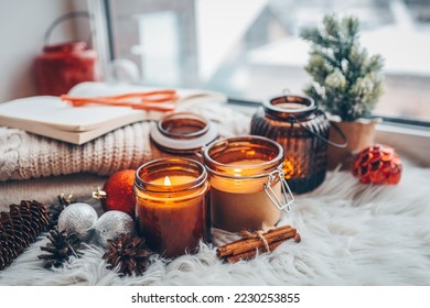 Soy candles burn in glass jars. Comfort at home. Candle in a brown jar. Scent and light. Scented handmade candle. Aroma therapy. Christmas tree and winter mood. Cozy decor. Festive garland decoration. - Powered by Shutterstock